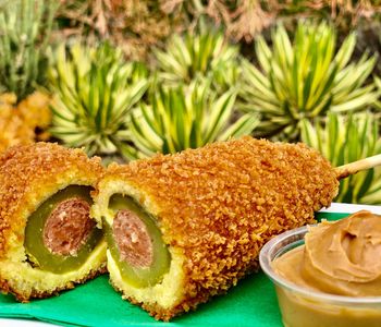 Disney just announced their latest delicacy, a fried pickle corn dog: a hot dog stuffed in a dill pickle, then battered, panko-crusted, fried, served with peanut butter. Would you want to try one?